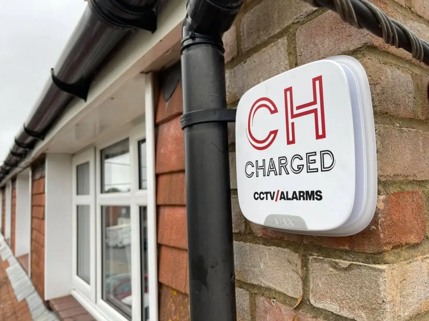 Charged Services alarm box installed on property exterior